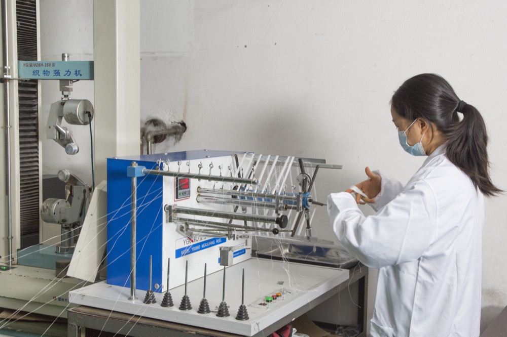 Technician running a tension test on the QC bench